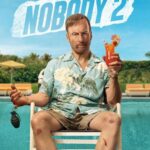Official movie poster for Nobody 2, featuring Bob Odenkirk as Hutch Mansell, bruised and with cuts on his face, sitting on a poolside chair in a Hawaiian shirt and shorts, holding a grenade in one hand and a tropical drink in the other. The tagline reads "NOBODY RUINS HIS VACATION."