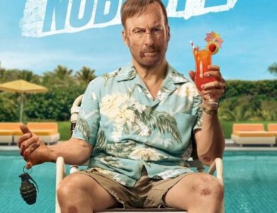 Official movie poster for Nobody 2, featuring Bob Odenkirk as Hutch Mansell, bruised and with cuts on his face, sitting on a poolside chair in a Hawaiian shirt and shorts, holding a grenade in one hand and a tropical drink in the other. The tagline reads "NOBODY RUINS HIS VACATION."