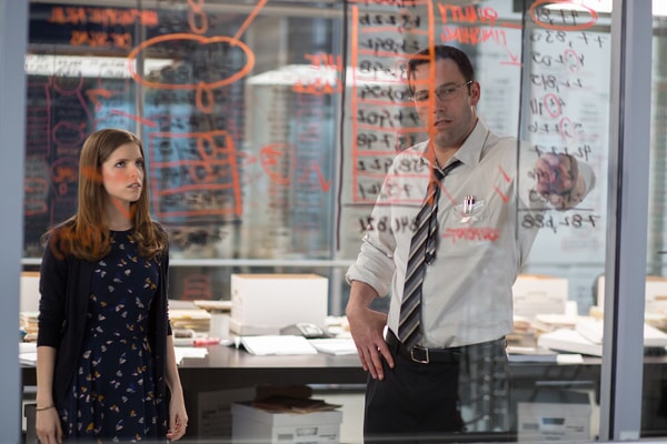 Christian Wolff (Ben Affleck) and Dana Cummings (Anna Kendrick) intensely focused on papers, possibly working on the Living Robotics audit in The Accountant.