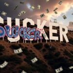 The iconic Hollywood sign on a hill, with the word "SUCKER" spray-painted in bold, graffiti-style letters across its face, while dollar bills rain down from a dramatic sky.