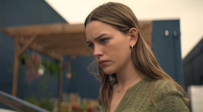 Victoria Pedretti as Love Quinn looking serious or troubled in a close-up shot from Season 2 of Netflix's YOU.