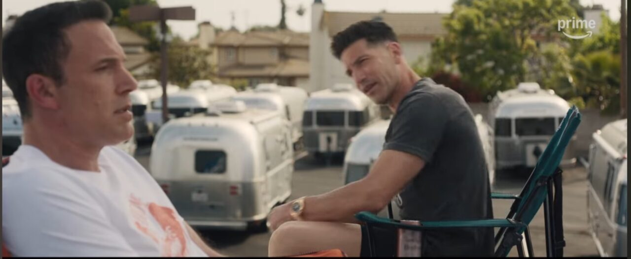Ben Affleck and Jon Bernthal seated outdoors in a casual conversation, possibly during a break from a mission in The Accountant 2.