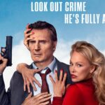 Liam Neeson with a serious expression, holding a handgun, while a woman with red nail polish (Pamela Anderson) embraces him from behind, set against a blue sky with palm trees.