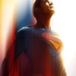 Superman, in his iconic blue and red suit with the S-shield, looks up intensely against a backdrop of glowing red, orange, and blue light streaks, conveying motion and power.