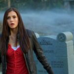 Nina Dobrev as Elena Gilbert in a cemetery with fog, looking surprised or startled.