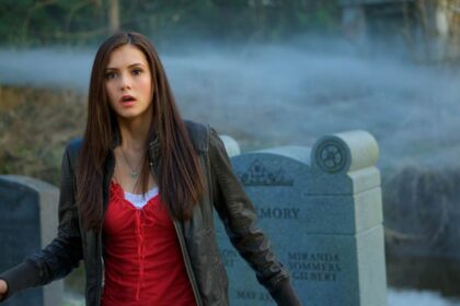 Nina Dobrev as Elena Gilbert in a cemetery with fog, looking surprised or startled.
