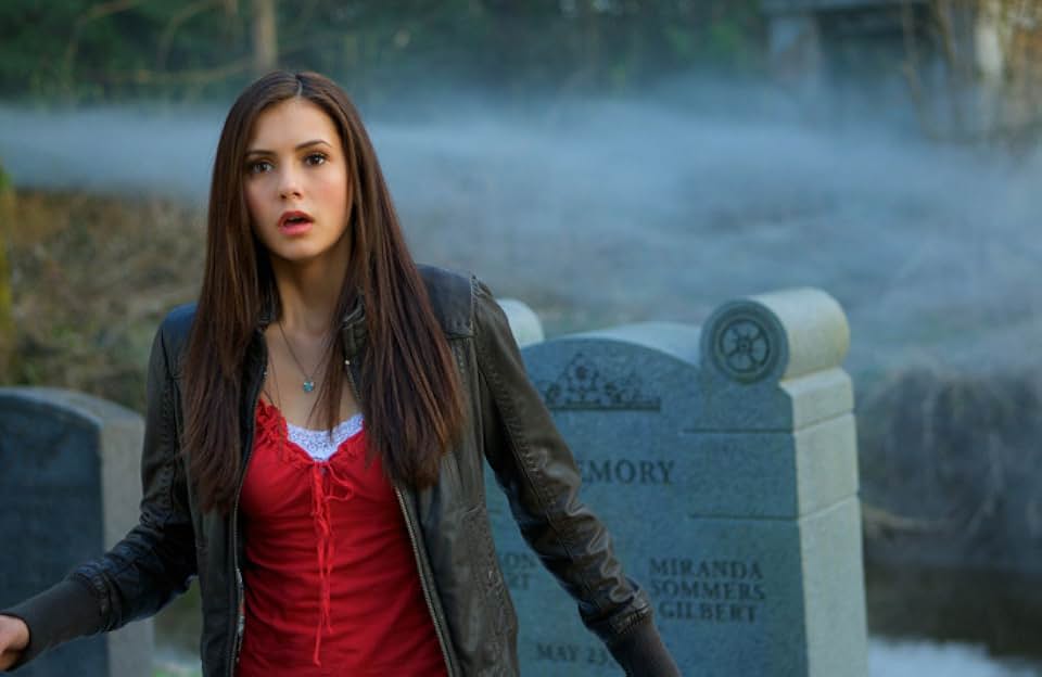 Nina Dobrev as Elena Gilbert in a cemetery with fog, looking surprised or startled.