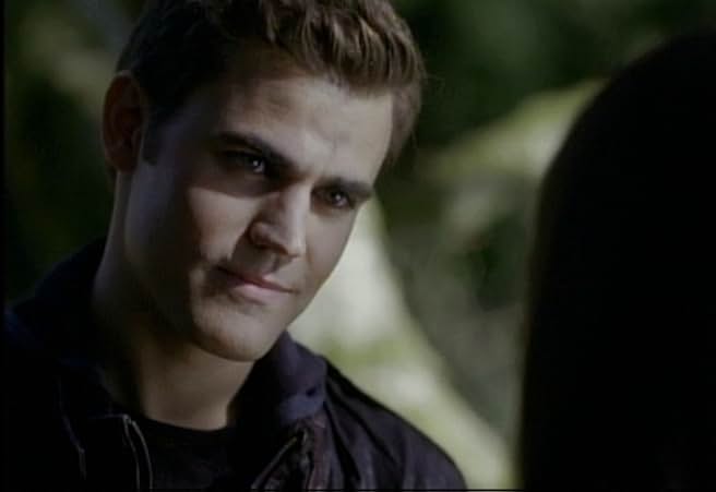 Paul Wesley as Stefan Salvatore looking brooding and intense in a close-up shot, possibly in a wooded area.