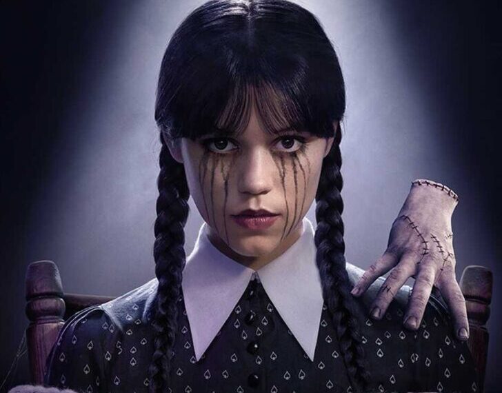 Wednesday Addams (Jenna Ortega) on the official Season 2 poster, tied with Thing on her shoulder, looking unimpressed.