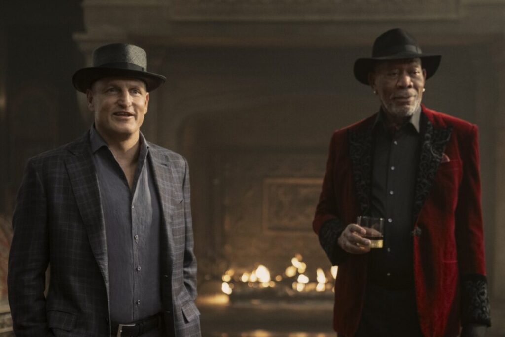 Thaddeus Bradley (Morgan Freeman) and Merritt McKinney (Woody Harrelson) in a well-lit, ornate room, both wearing hats and suits, in Now You See Me, Now You Don't.