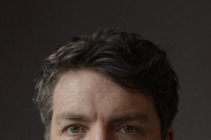 A headshot of Tom Burke.